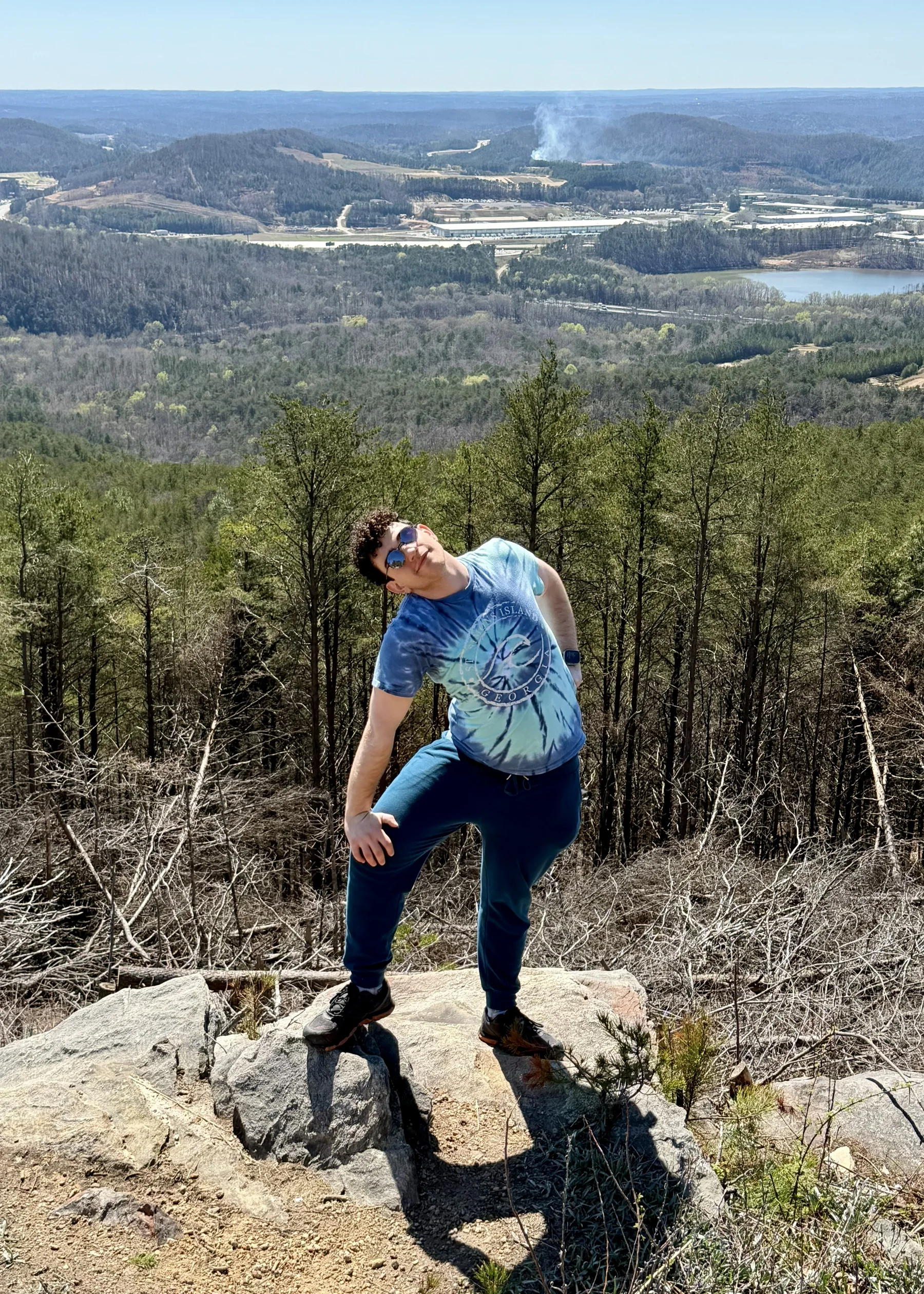 Drew stretching on a mountain overlook.
