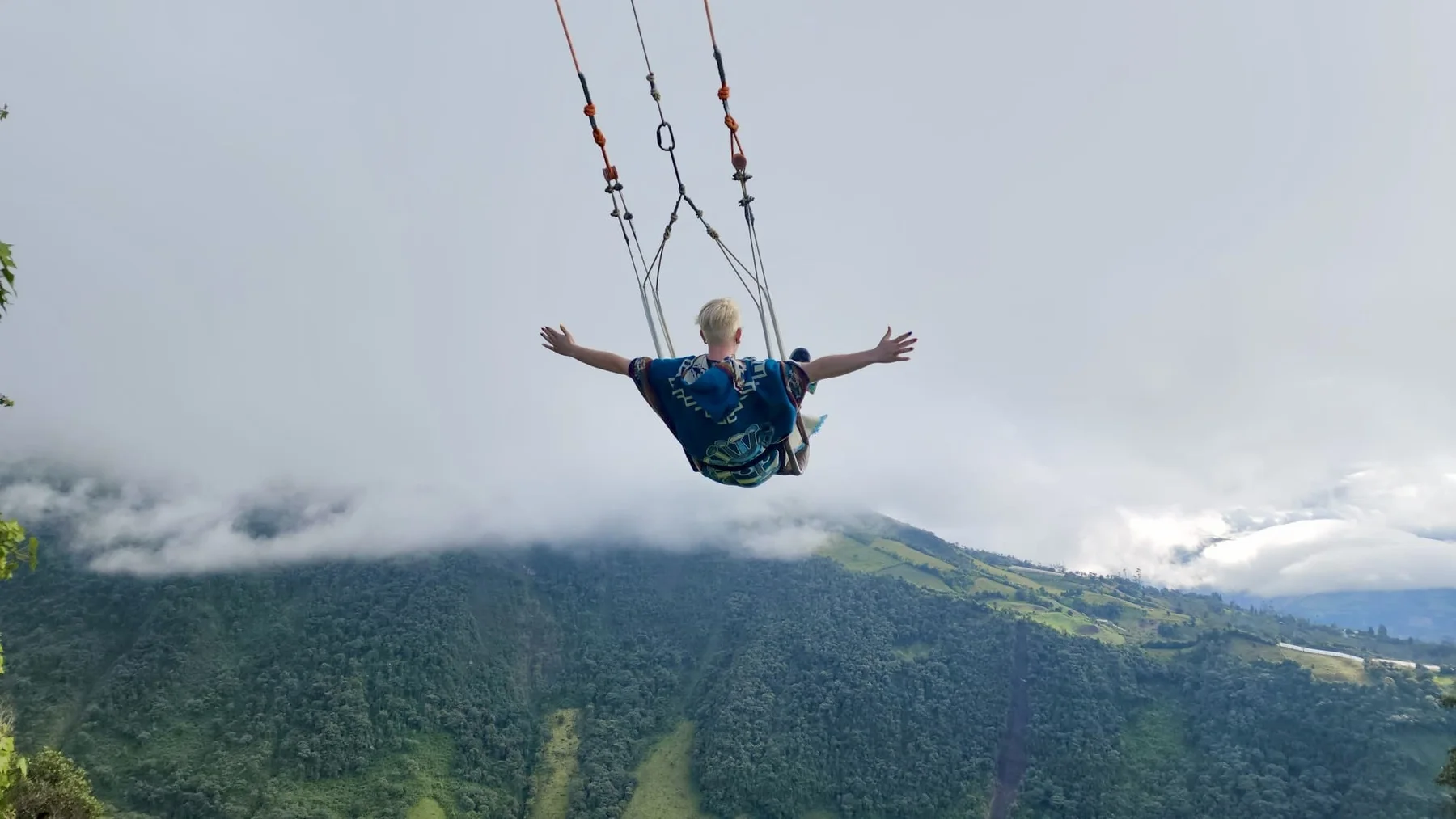 Drew on a wide mountain overlook with arms open toward the sky.