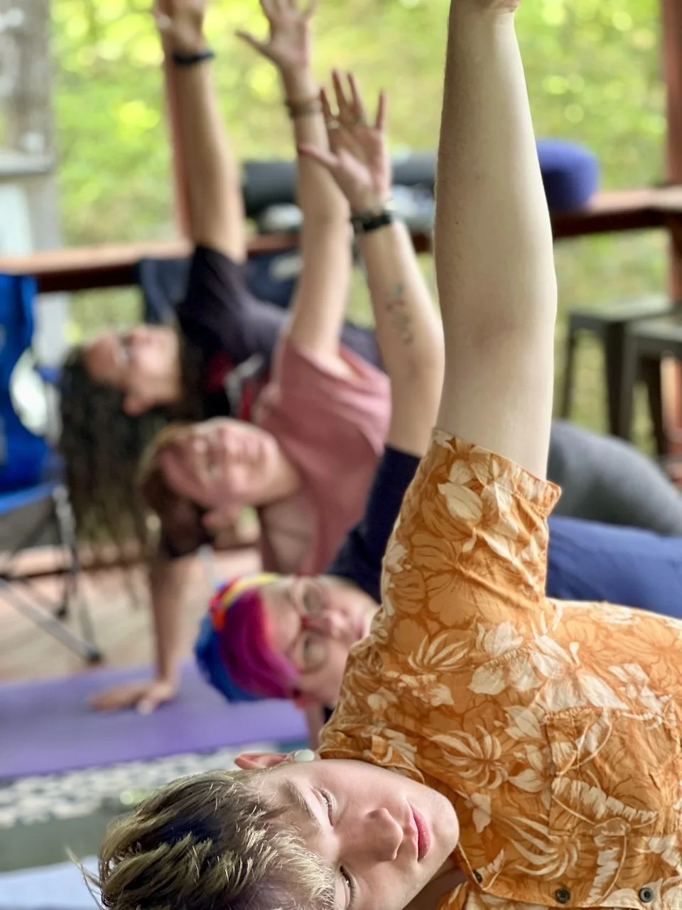 Students reaching upward during a shared yoga practice.