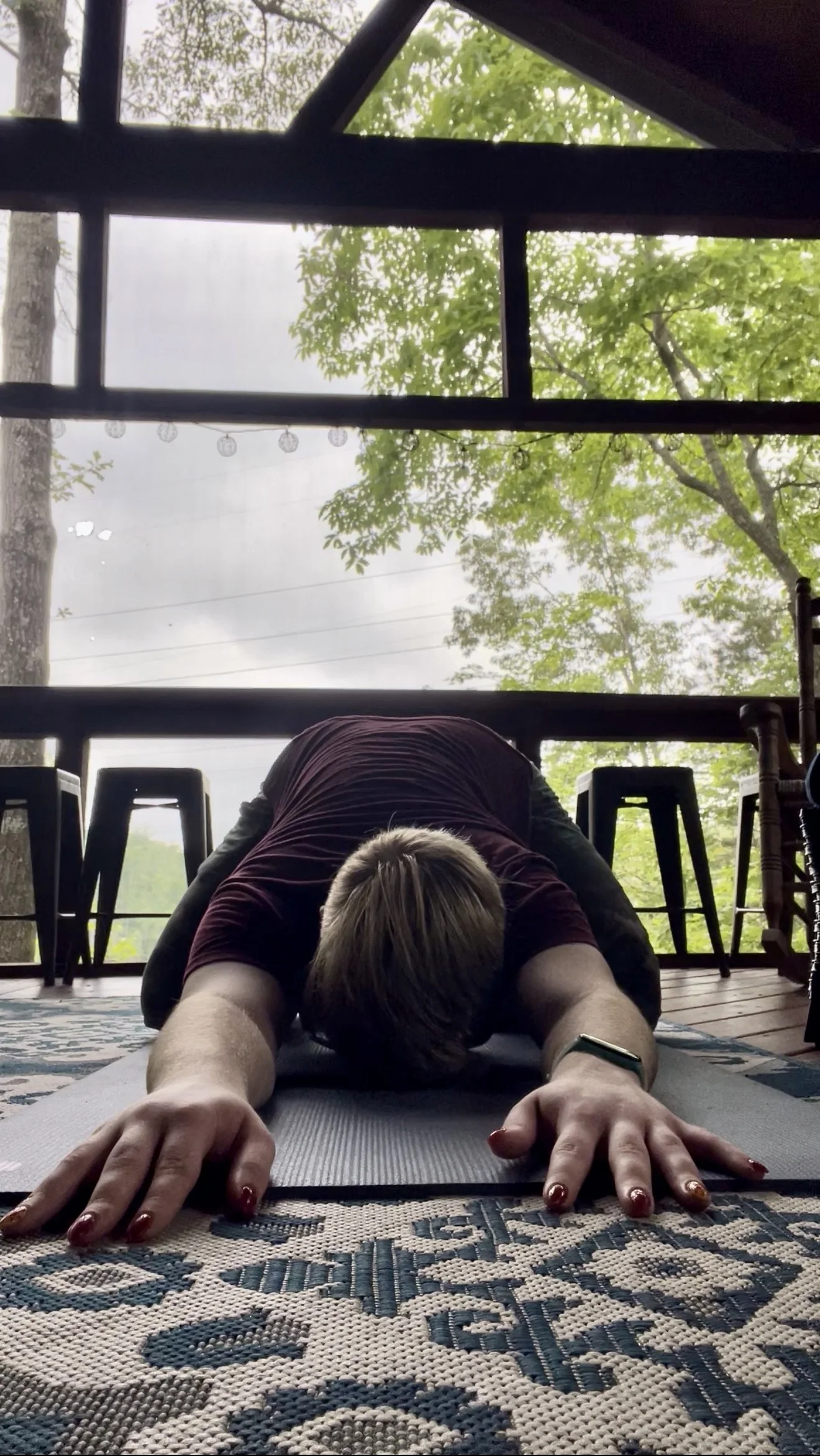 A student folding forward in a quiet grounded yoga posture.